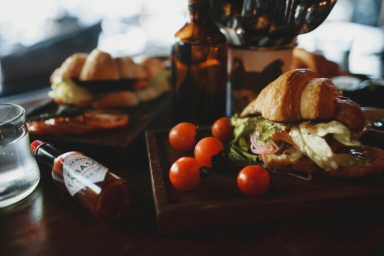 Crispy fresh croissant sandwich served with tomatoes in contemporary restaurant