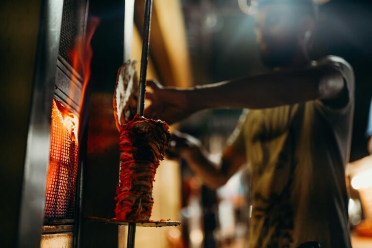 Person in Red and Black Dress Holding Shawarma Stick